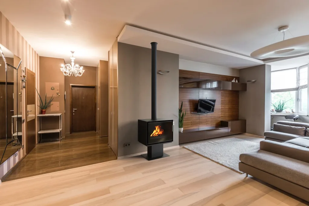 Poêle à bois Richard Le Droff Montmartre 800P sur pied, flamme visible, dans un séjour contemporain