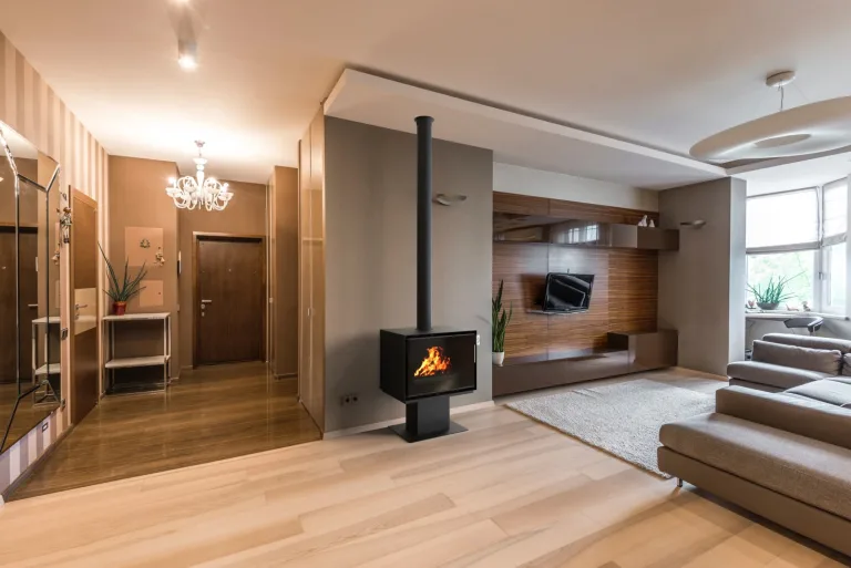 Poêle à bois Richard Le Droff Montmartre 800P sur pied, flamme visible, dans un séjour contemporain